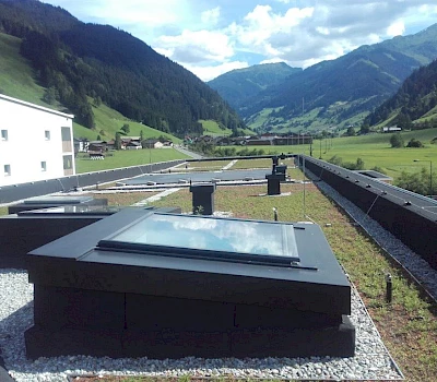 Grünes Dach des Kindergartens Großarl mit Blick Richtung Hüttschlag